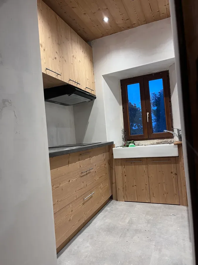Meubles de cuisine en bois sur-mesure aménagés autour d’une fenêtre