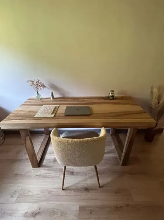 Bureau en bois massif clair à piètement en V dans un intérieur lumineux