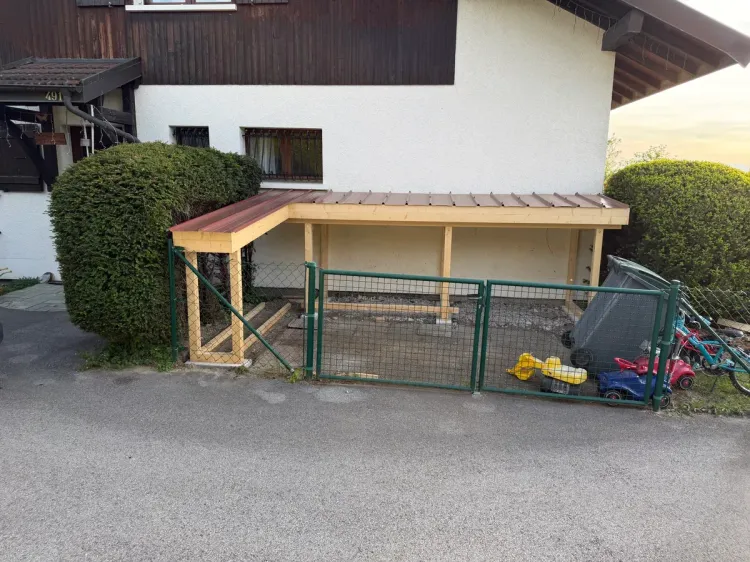 Abri bois abritant un espace de rangement le long d’une façade