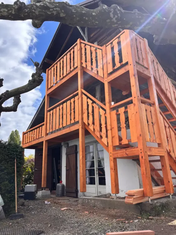 Balcons superposés et garde-corps en bois en cours de montage sur une maison