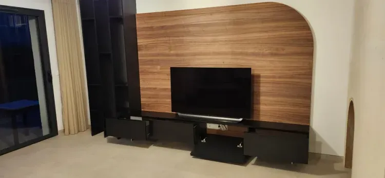 Meuble TV et habillage mural en bois dans un séjour aménagé par Rob’Art