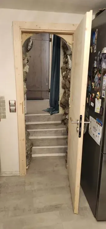 Escalier et porte en bois dans une entrée en pierre