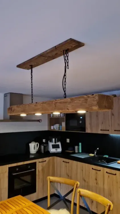 Poutre lumineuse en vieux bois au-dessus d’une cuisine