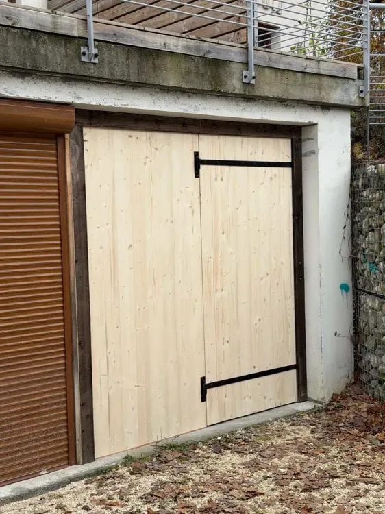 Porte de garage en bois clair avec ferrures noires